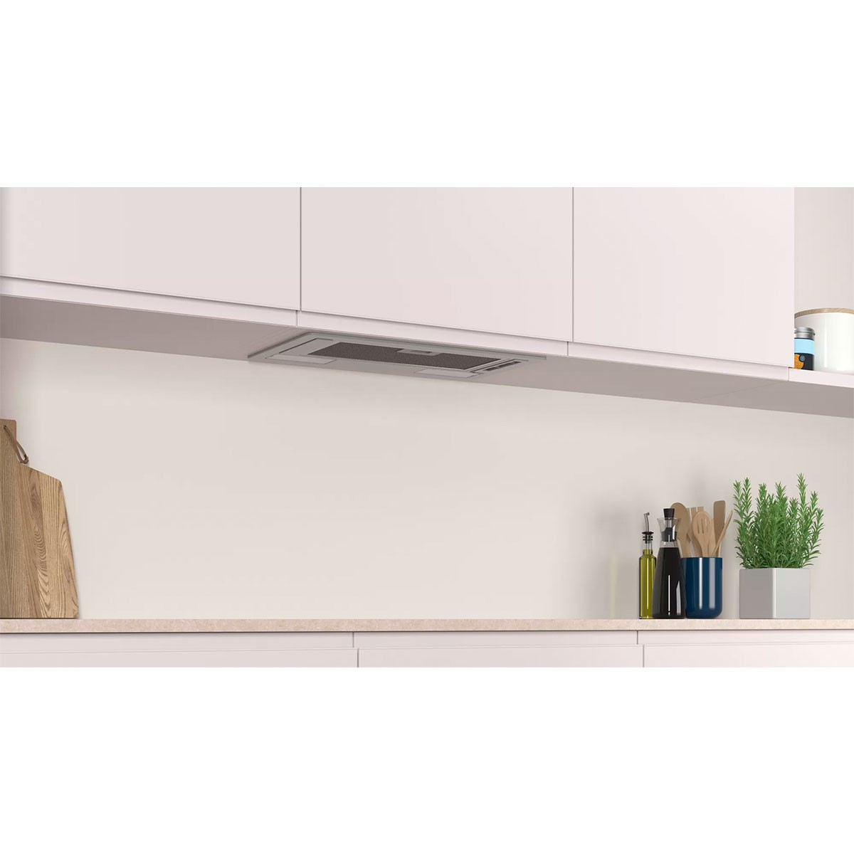 Cocina con campana extractora empotrada sobre la encimera, con varios objetos.