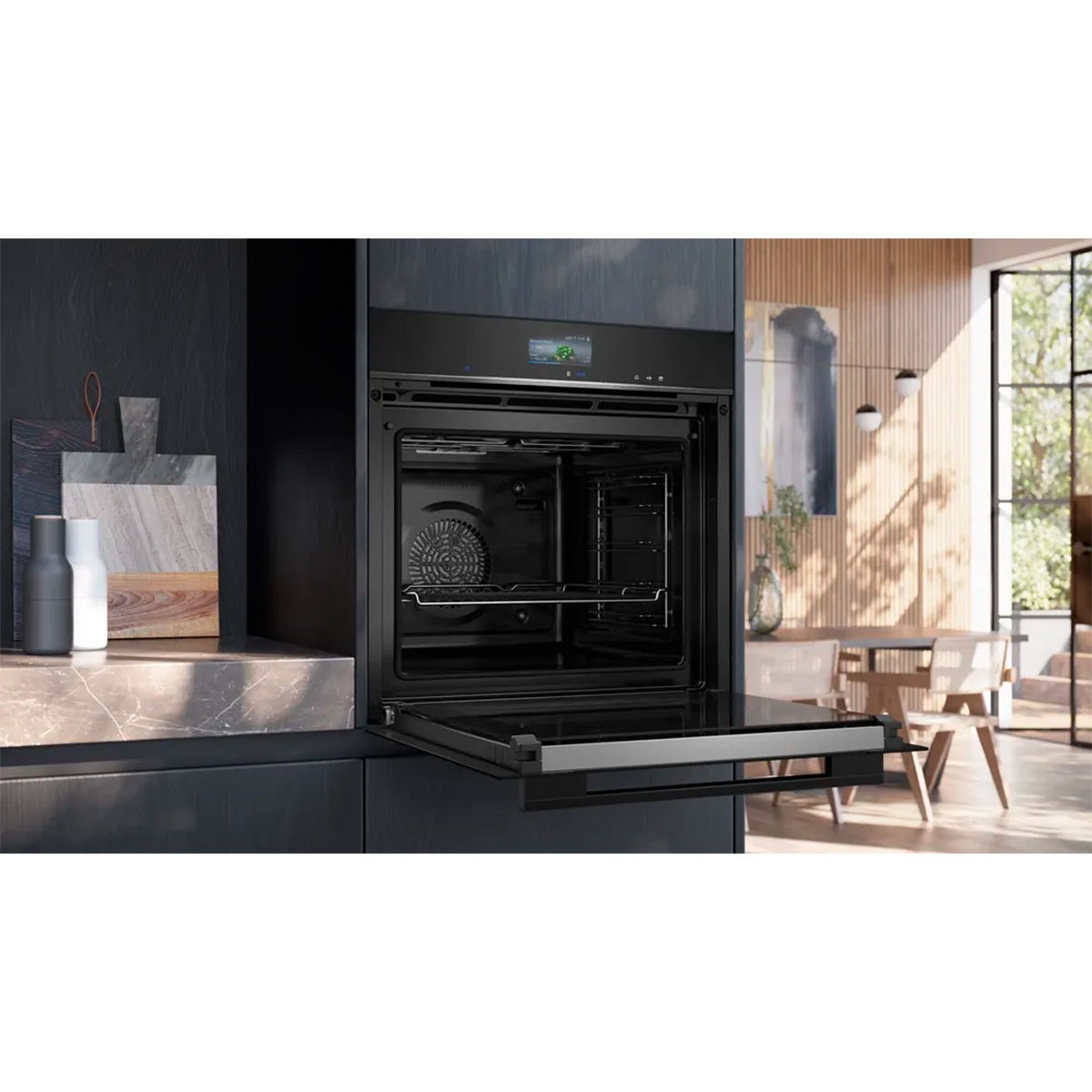 Zwarte oven met open deur in een moderne keuken. Er is een snijplank, zout- en pepervaatjes en een tafel op de achtergrond.