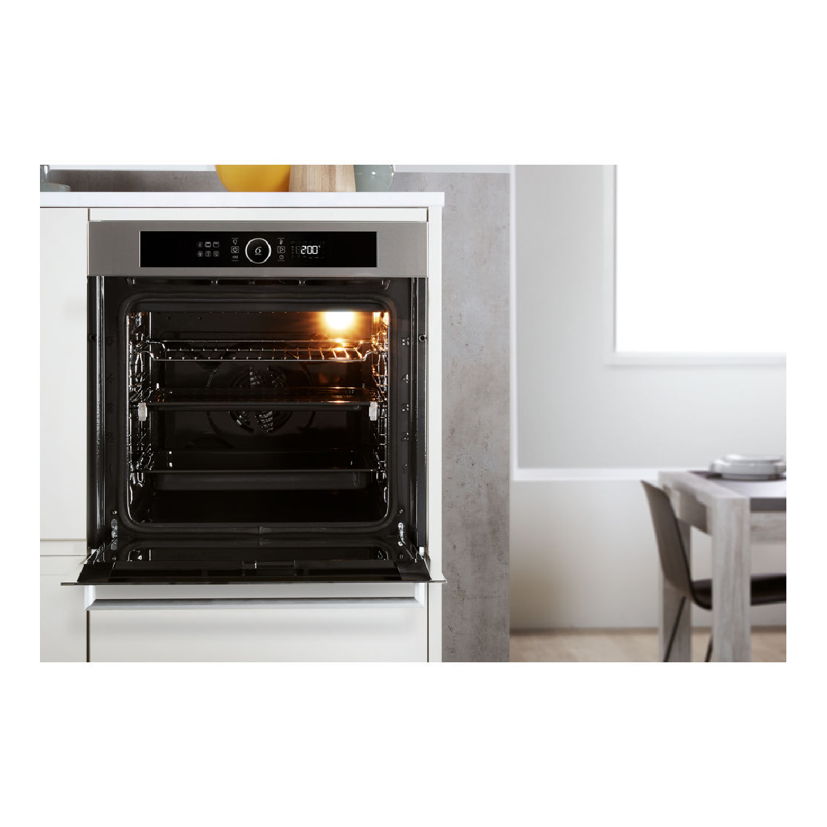 Horno con la puerta abierta, luz interior encendida, a 200 grados. Fondo de cocina.
