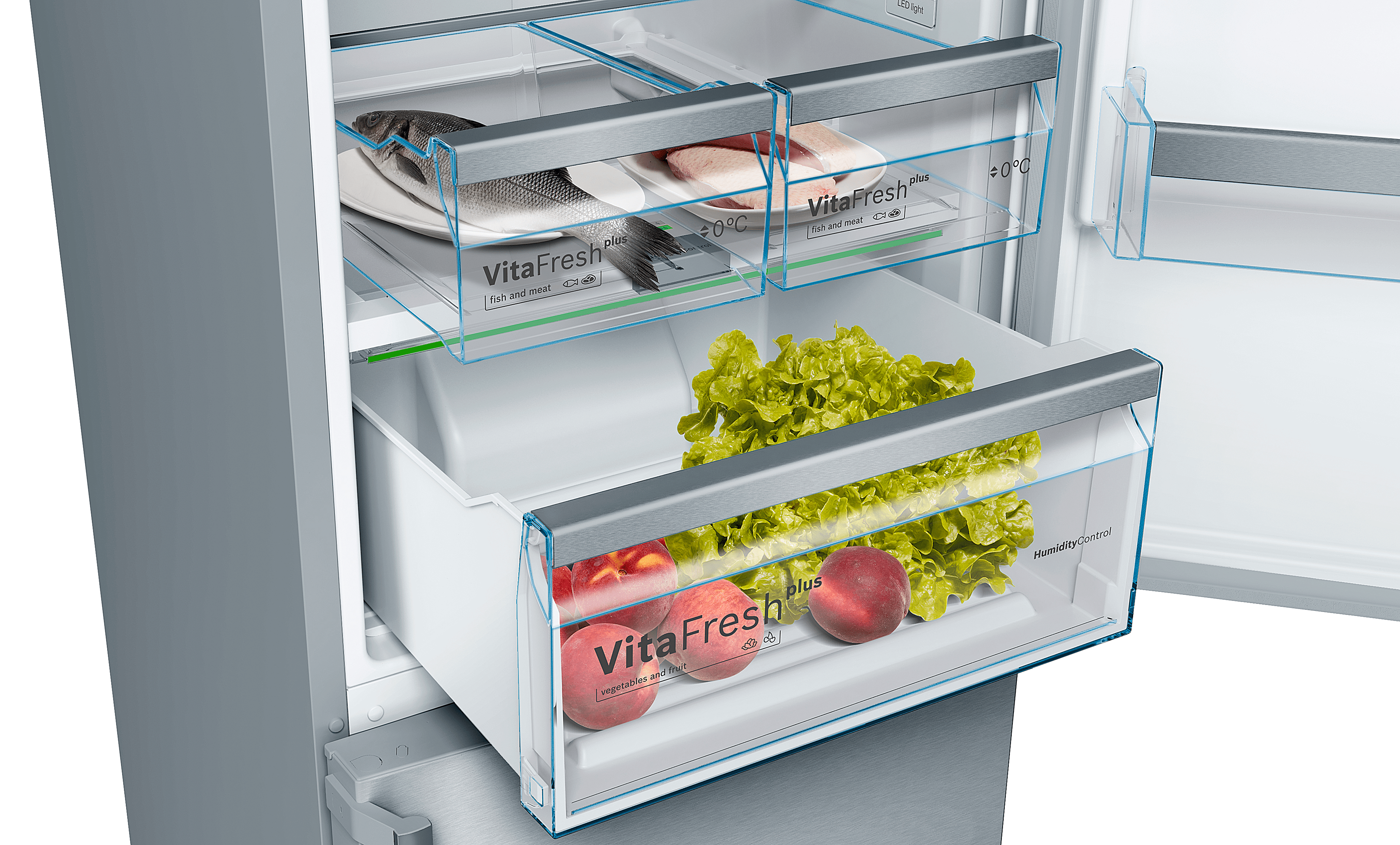 Interior de refrigerador con comida. Incluye pescado, lechuga y duraznos en cajones.