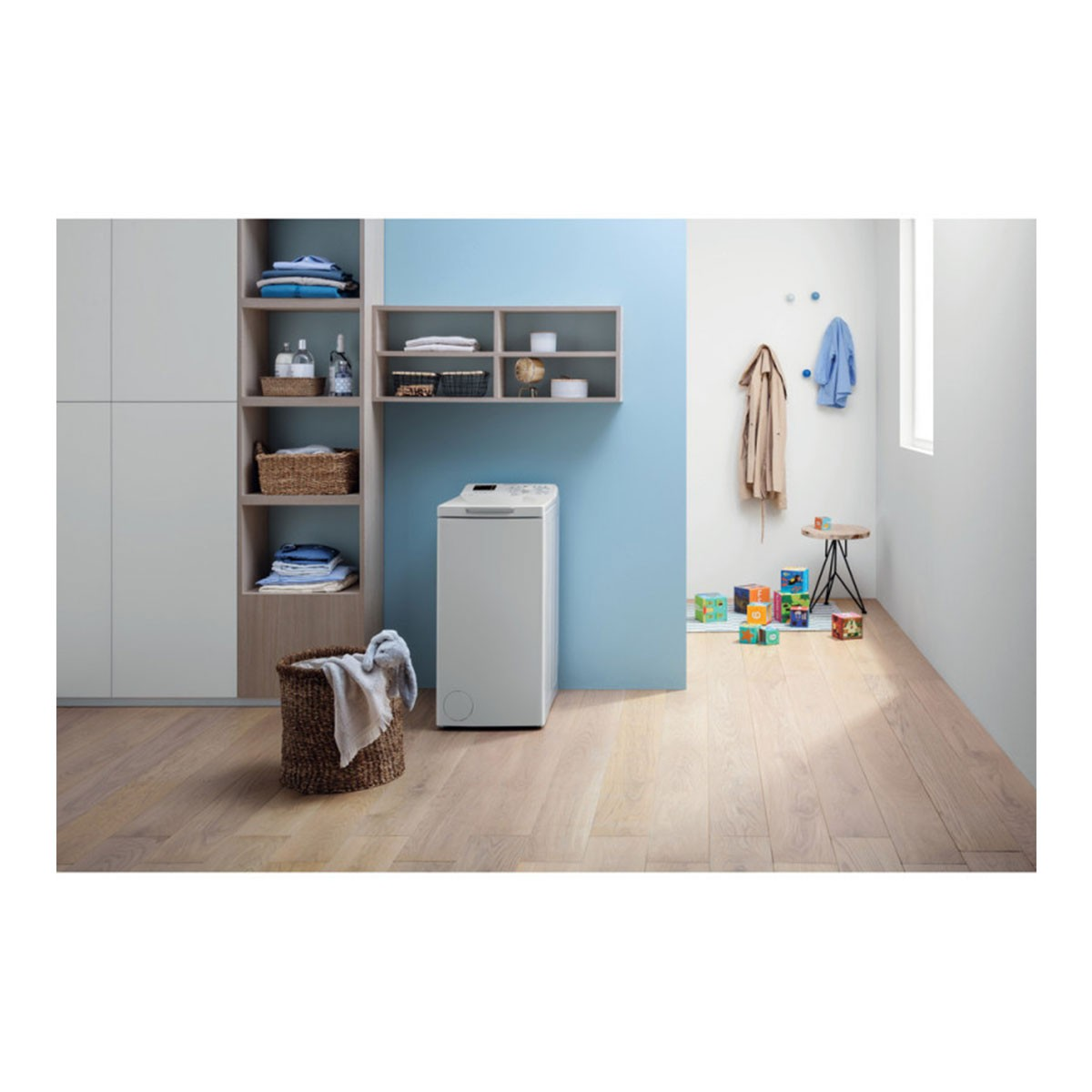 Cuarto de lavado con lavadora, cestas, estantes y pared azul con ganchos.