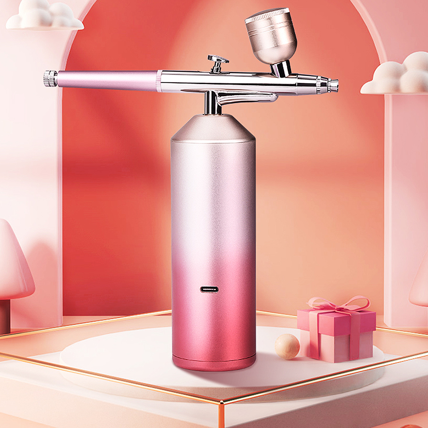 Un aerografo rosa, con base rosa e argento, su una superficie rosa.