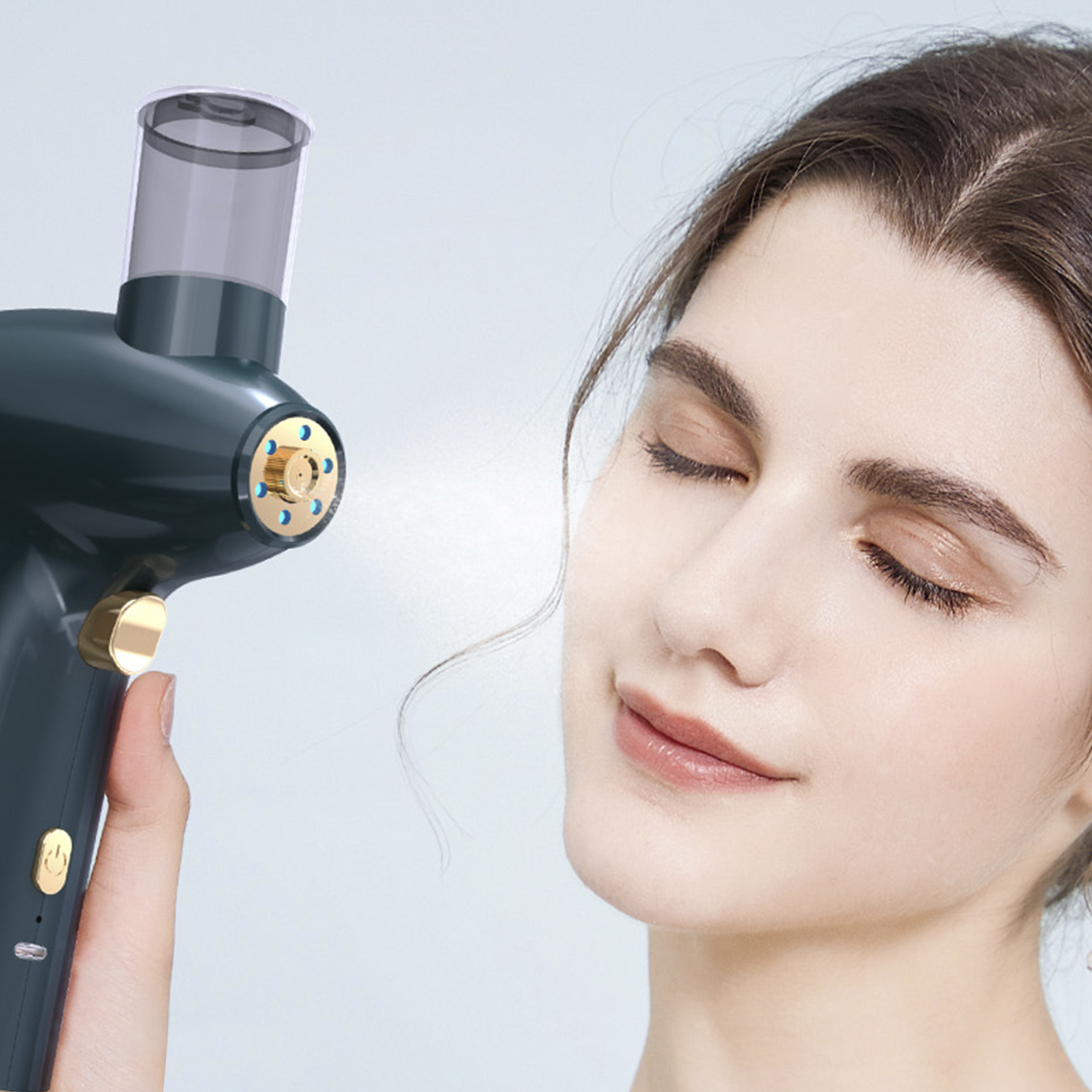 Una mujer con los ojos cerrados sostiene un nebulizador facial. El nebulizador es verde oscuro con detalles dorados.