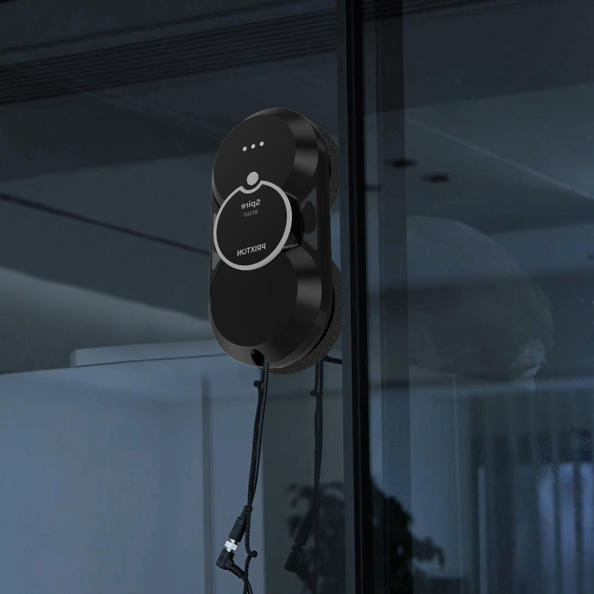 A black window cleaning robot is attached to a glass window.