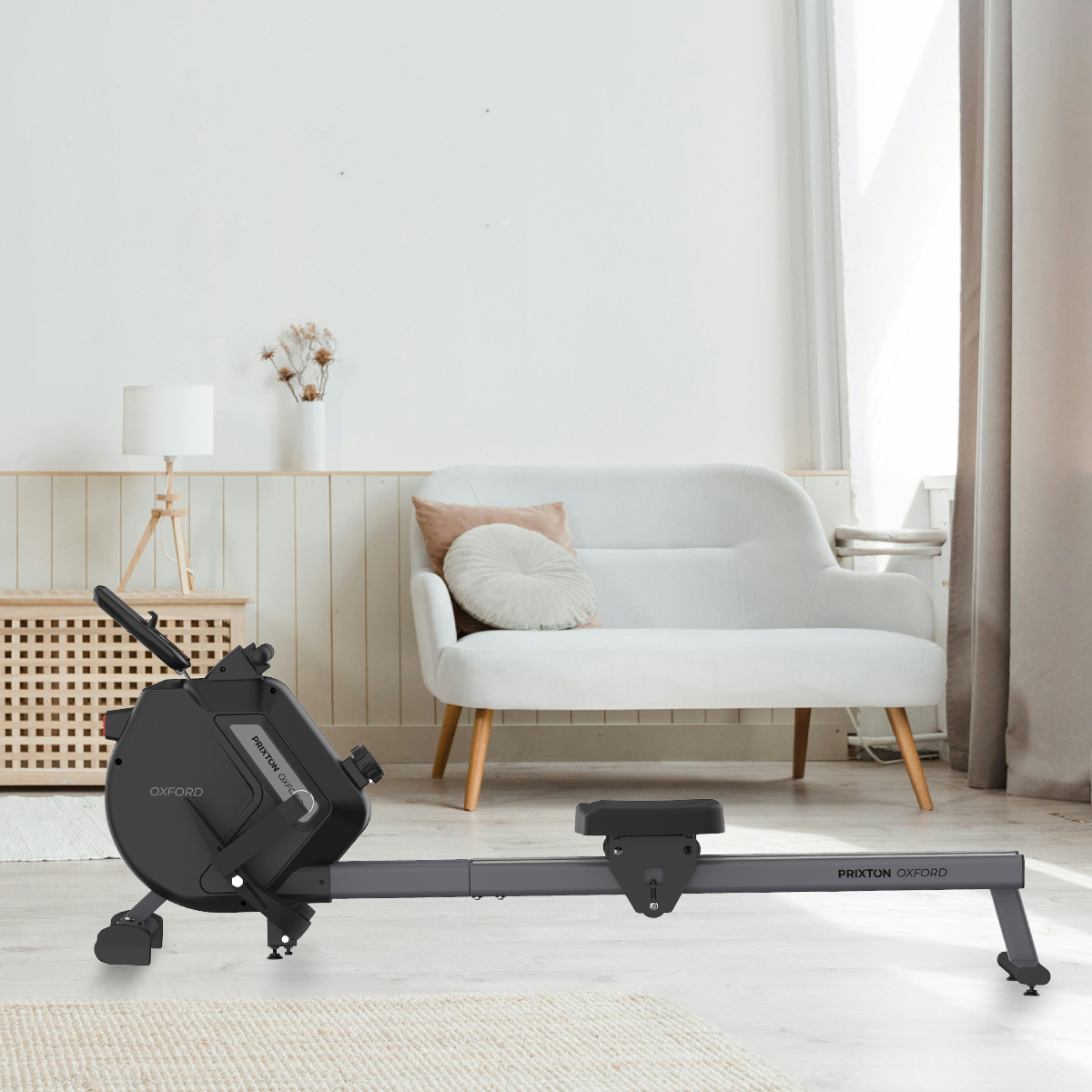 Wioślarz w pokoju. W tle biała kanapa i drewniana szafka.