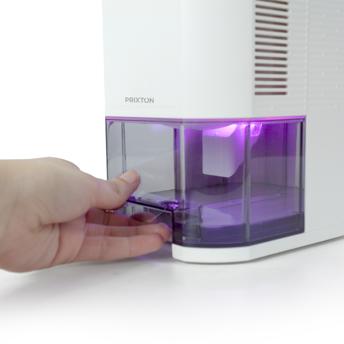 Ręka wyciąga przezroczysty plastikowy zbiornik na wodę z białego urządzenia, z fioletowym oświetleniem.