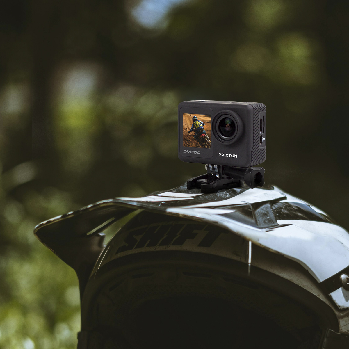 Czarna kamera sportowa zamontowana na kasku, z tłem lasu.