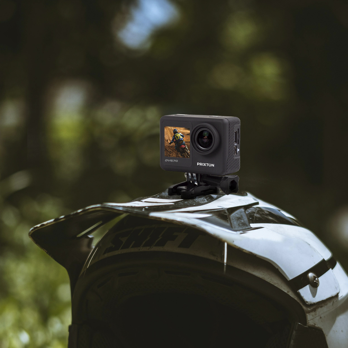 Czarna kamera sportowa na kasku. Tło to rozmyte zielone drzewa.