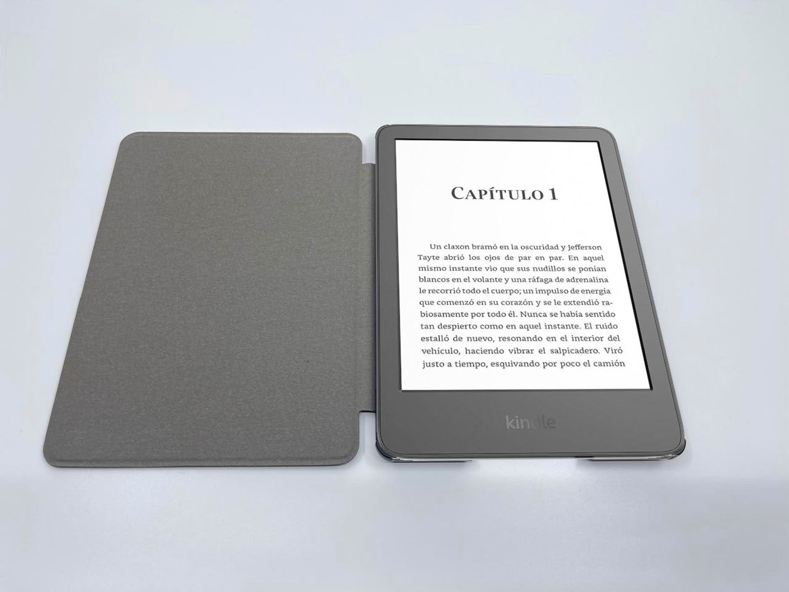 Un lector de libros electrónicos abierto mostrando texto. La cubierta está abierta y el libro sobre superficie blanca.