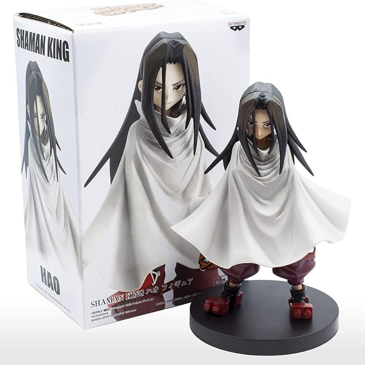Eine Shaman King Figur und ihre Box, die eine Figur in weißem Gewand mit langen schwarzen Haaren zeigt.