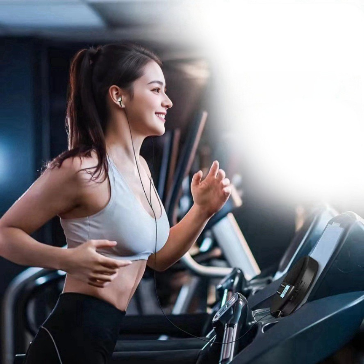 Frau läuft auf dem Laufband mit Ohrhörern. Verschwommener Hintergrund mit Fitnessgeräten.