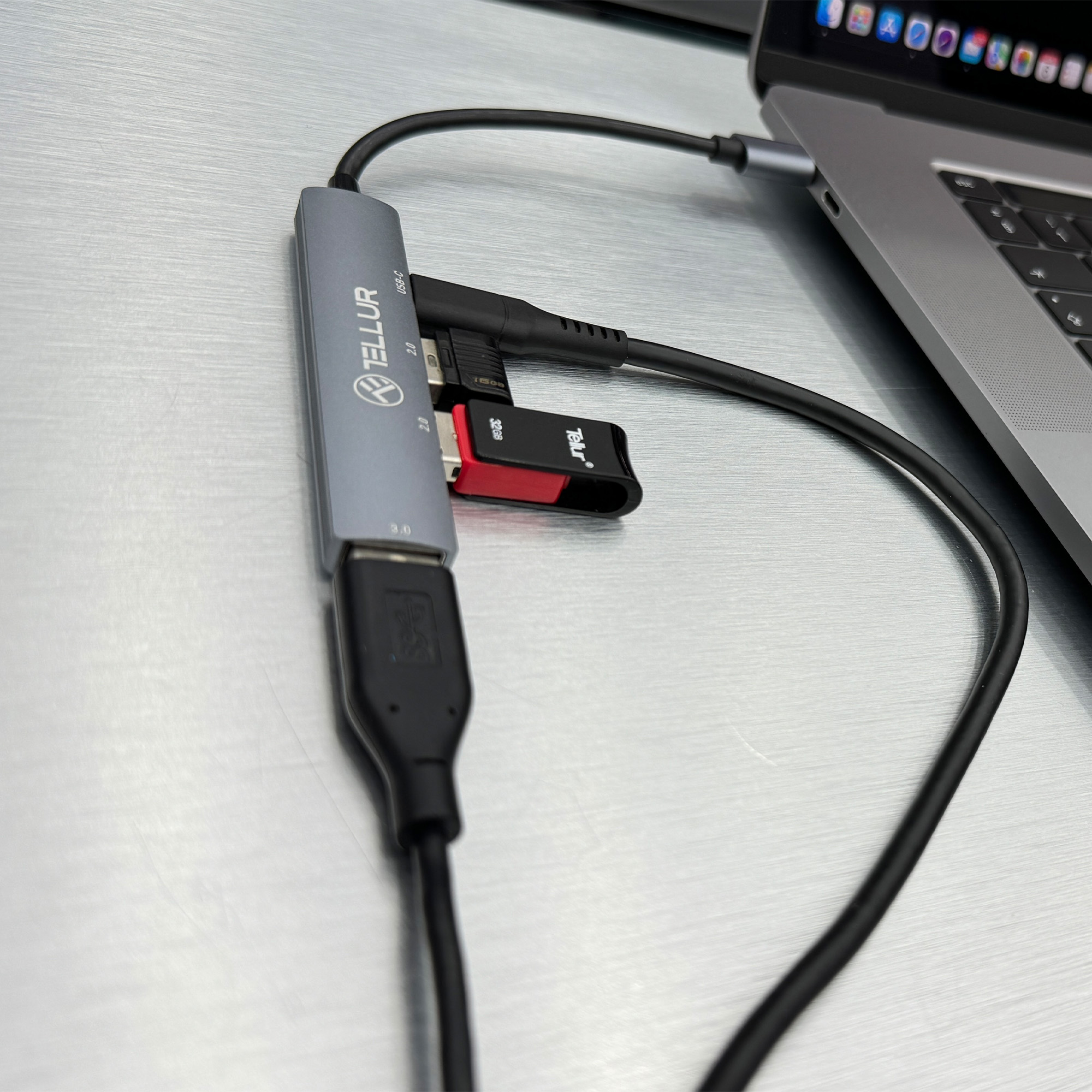Hub USB z wieloma portami podłączony do laptopa i innych urządzeń.