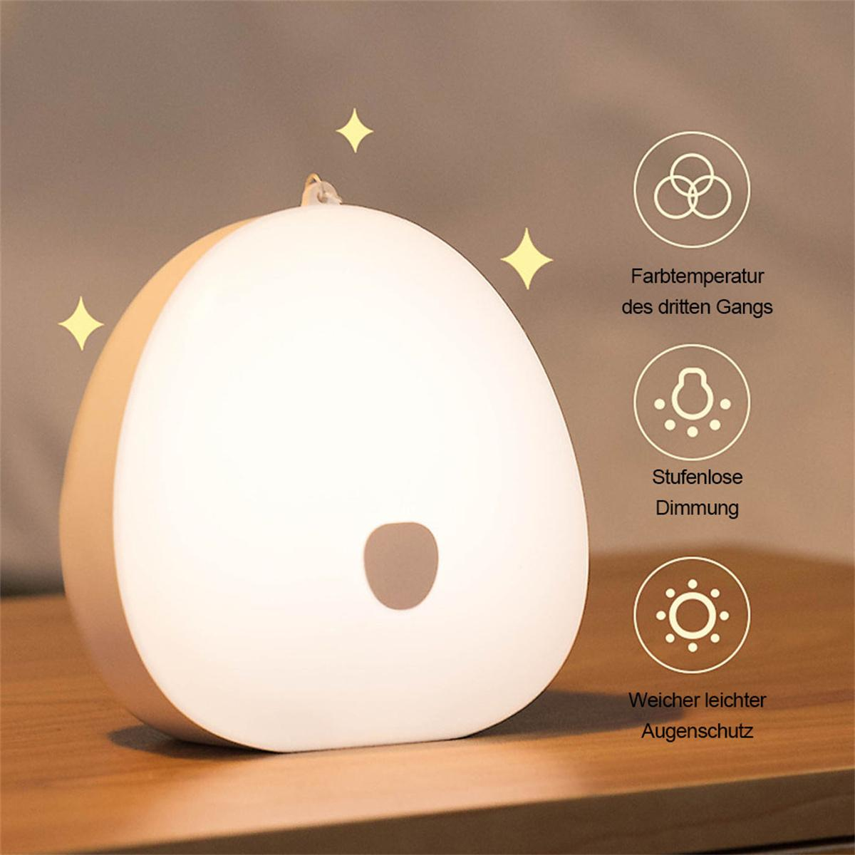 Eine weiße, eiförmige Lampe mit einem braunen Knopf. Sterne befinden sich im oberen Teil des Bildes.
