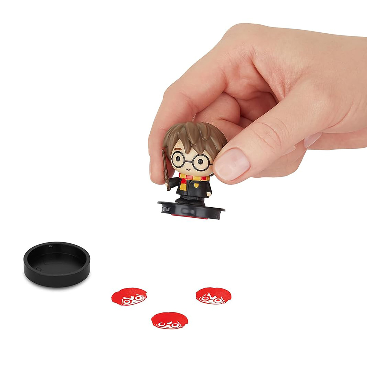 Eine Harry Potter-Figur mit Zubehör: Zauberstab, Brille und drei rote Gesichtsmarken, auf weißem Hintergrund.