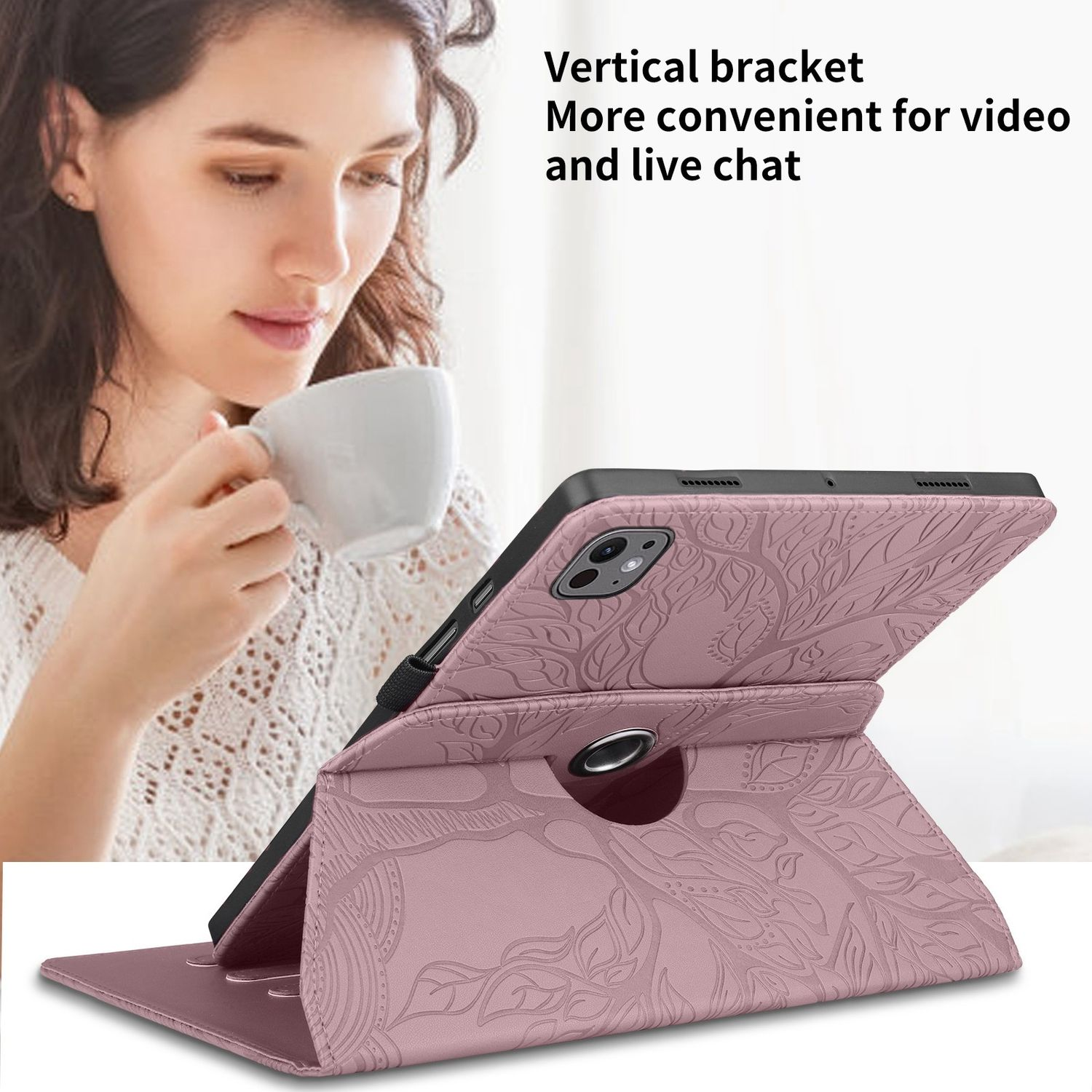 Una tableta está en una funda rosa, apoyada en un escritorio. Una mujer sostiene una taza en el fondo.