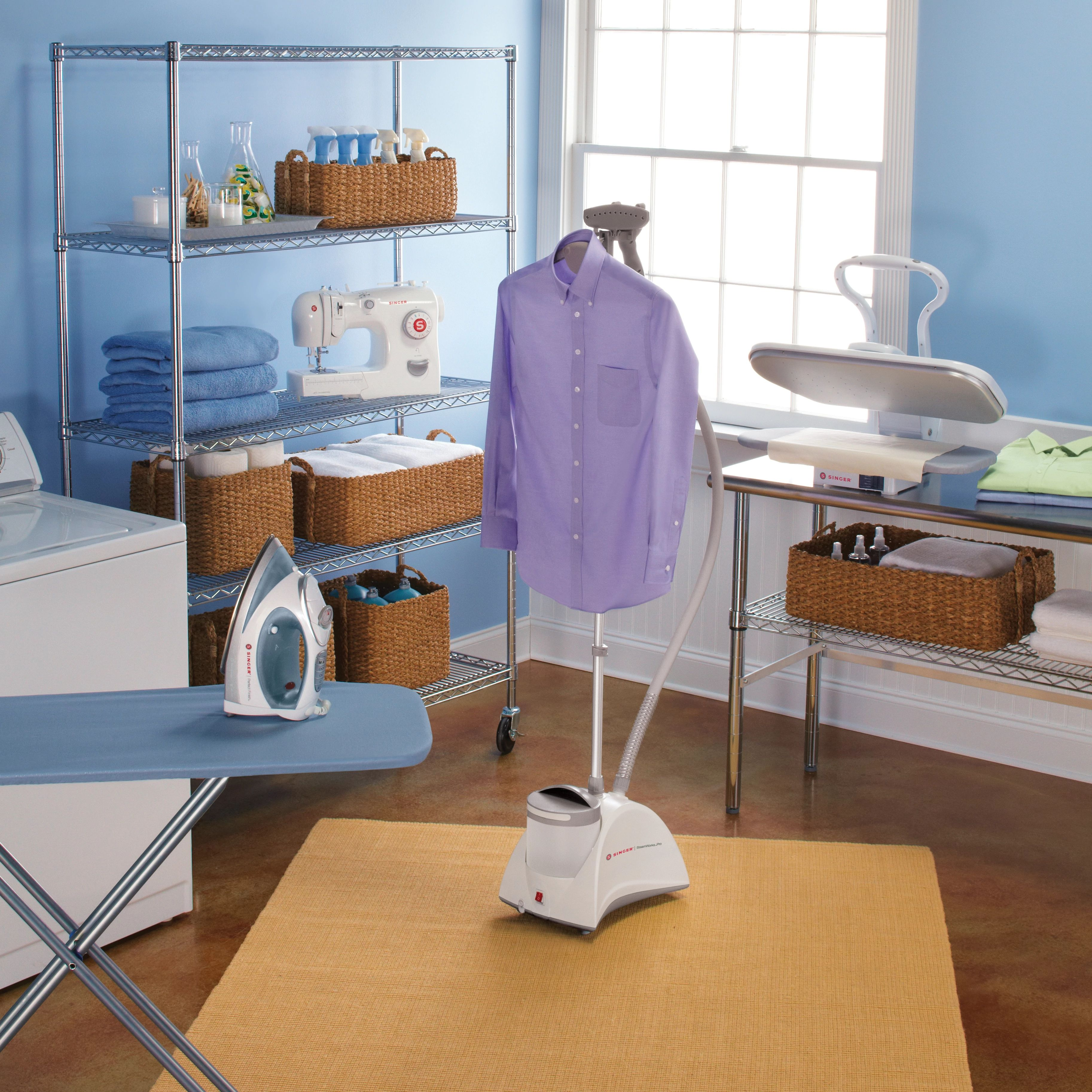 Laundry room with ironing board, iron, steamer, and shelves with baskets, sewing machine and shirt.