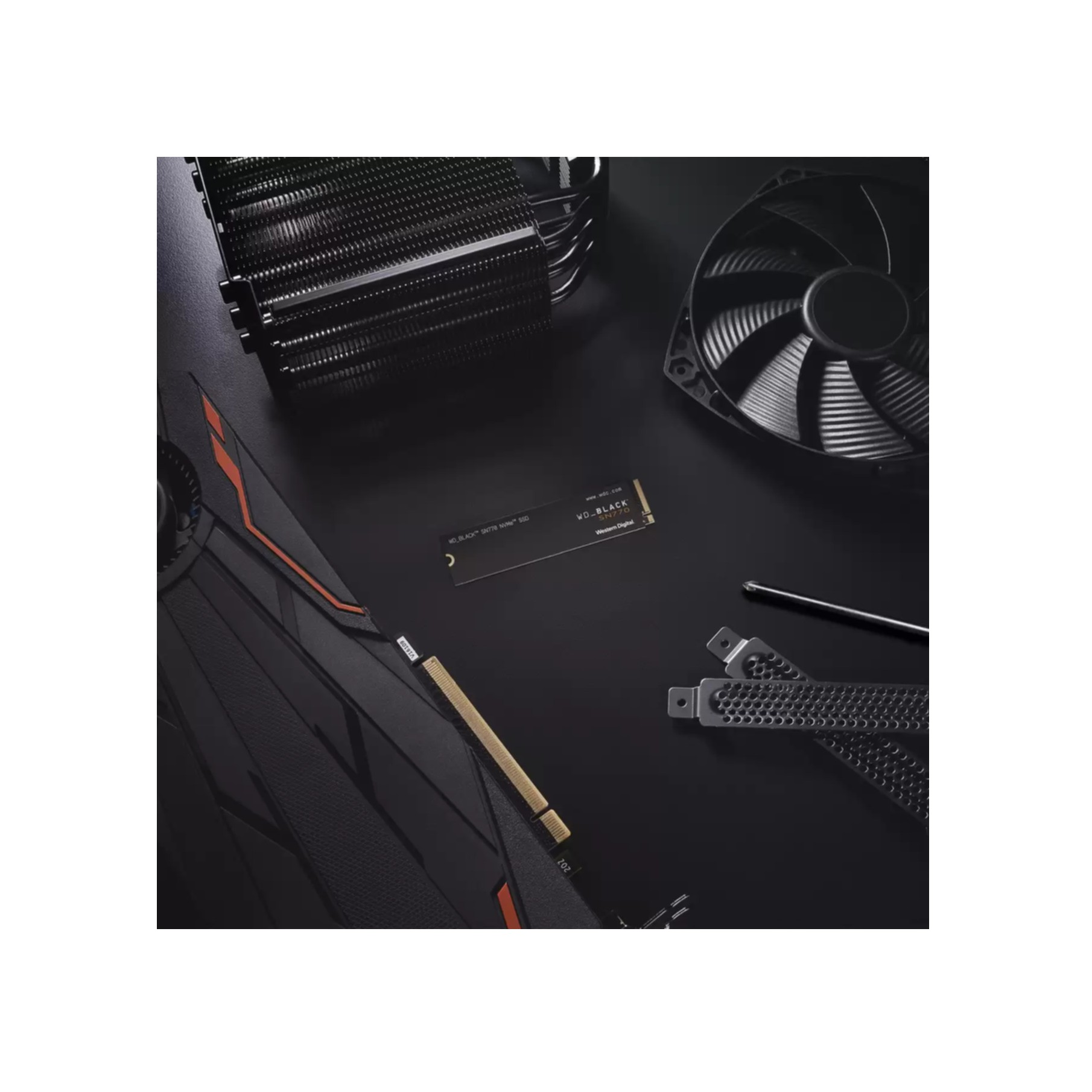 SSD noir avec d'autres composants matériels PC sur une surface sombre.