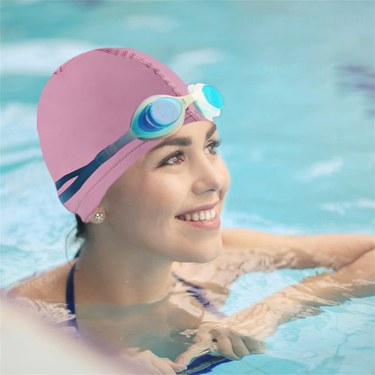 Frau im Pool mit rosa Badekappe und Schwimmbrille. Lächelt, blickt nach rechts. Wasser und Himmel im Hintergrund.