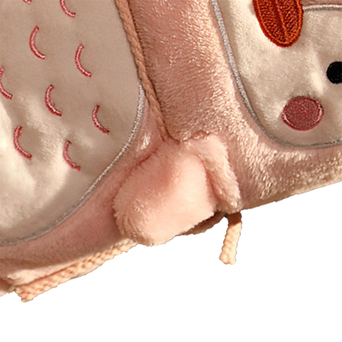 Nahaufnahme eines rosa, plüschigen eulenformigen Artikels mit Nähdetails.