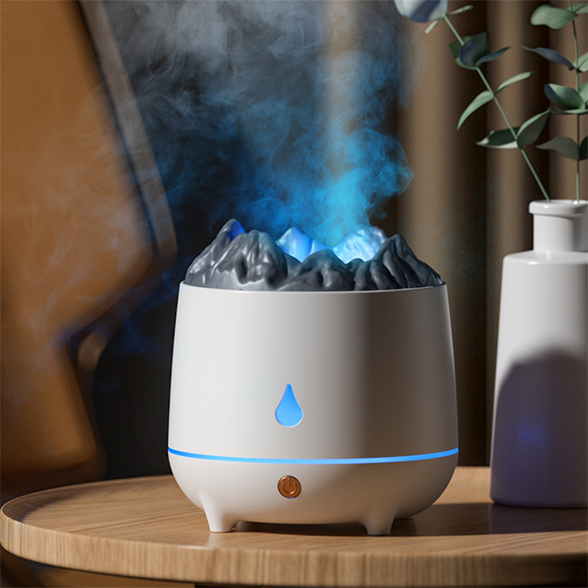 Weißer Diffusor für ätherische Öle mit bergförmigem Aufsatz, der blauen Dampf ausstößt, auf einem Holztisch.