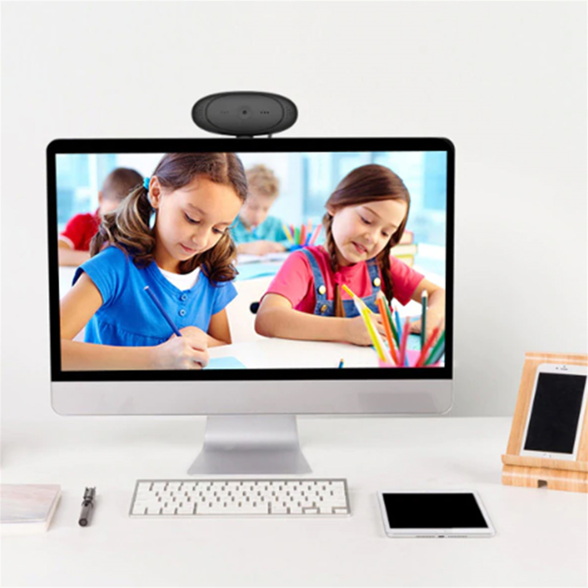 Ein Computermonitor zeigt zwei Mädchen beim Zeichnen. Über dem Bildschirm befindet sich eine Webcam.