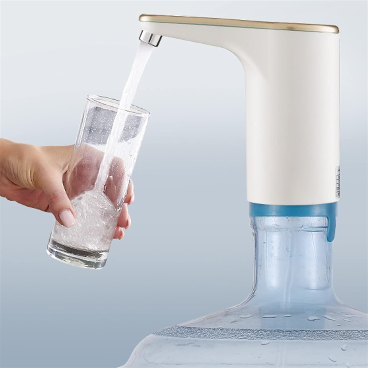 Frau füllt ein Glas mit Wasser aus einem elektrischen Wasserspender, klares Glas und blaue Flasche.