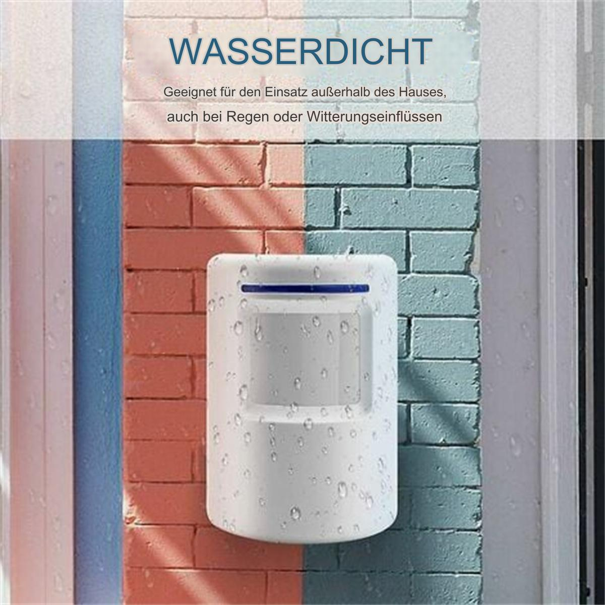 Ein weißer Bewegungssensor an einer rot-blauen Ziegelmauer mit Wassertropfen.