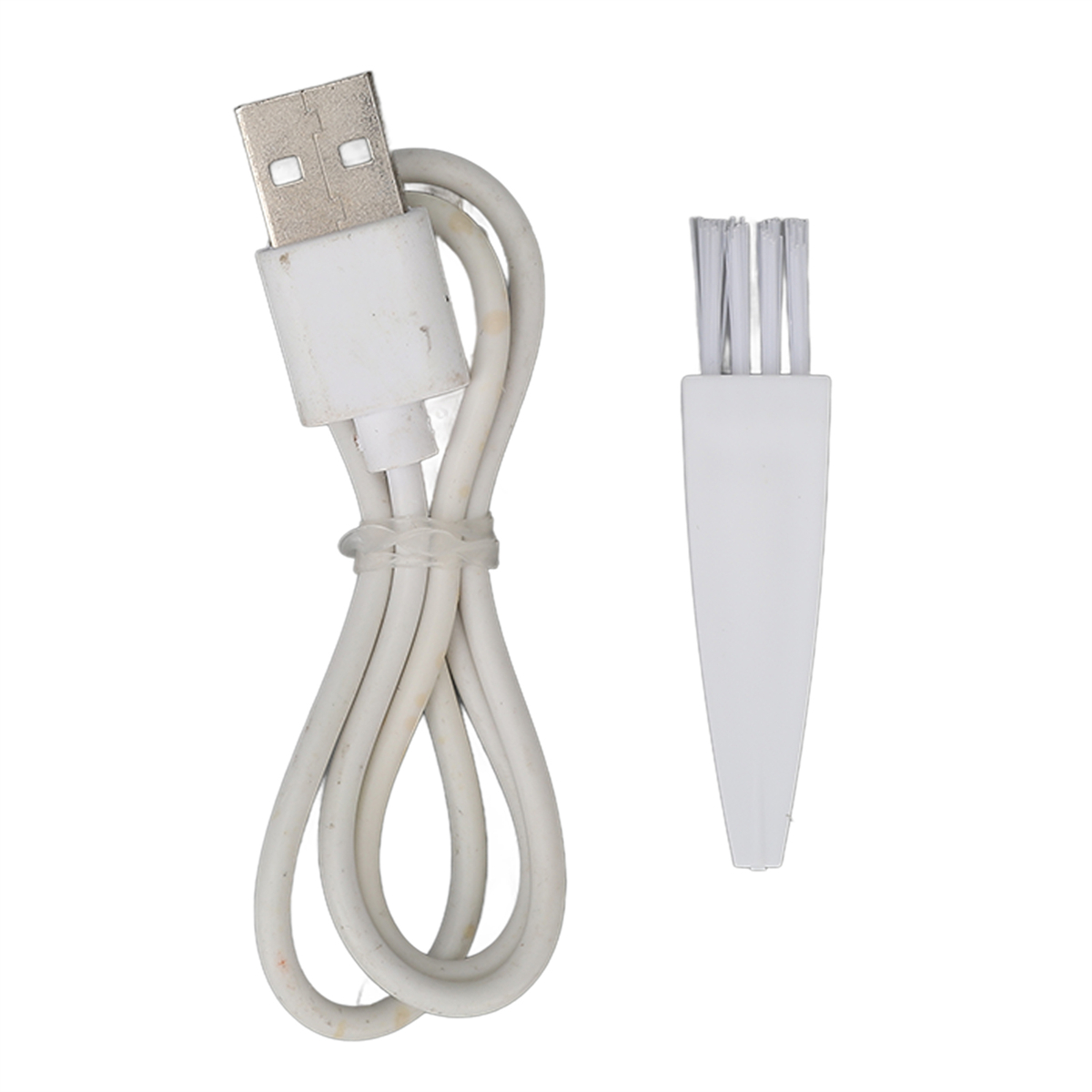 Ein weißes USB-Ladekabel und eine kleine Bürste zur Reinigung, auf weißem Untergrund dargestellt.