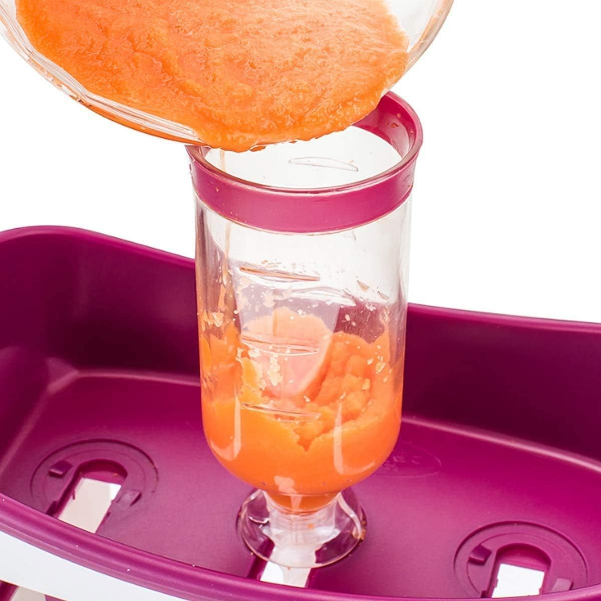 Orangenpüree wird aus einer Glasschüssel in einen transparenten Behälter mit Markierungen gegossen. Lila Basis.