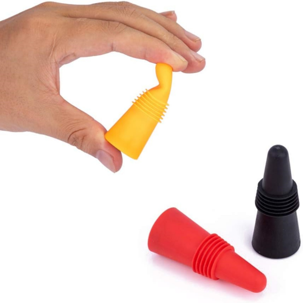 Eine Hand, die einen gelben Weinverschluss hält, mit zwei weiteren Verschlüssen in Rot und Schwarz.