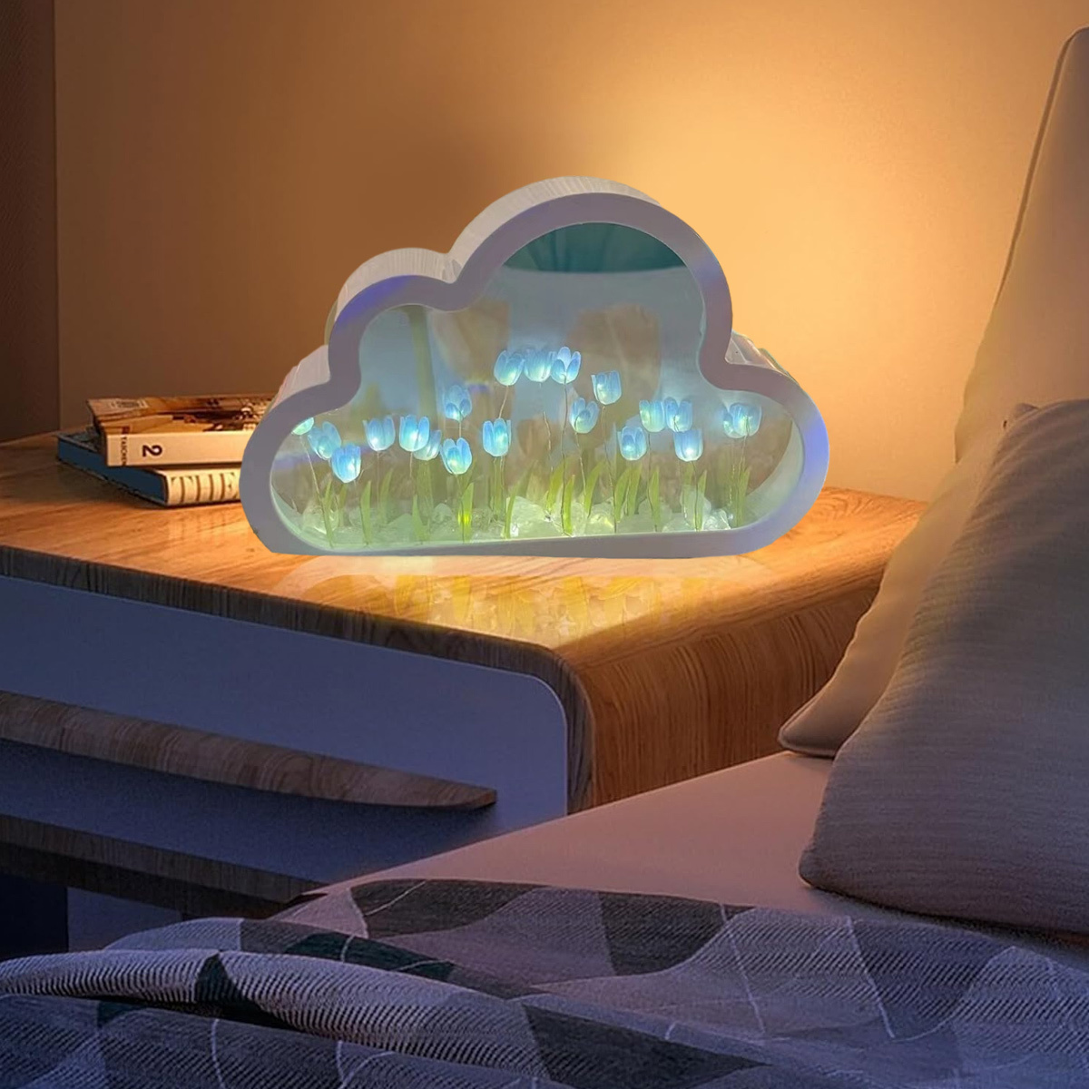 Wolkenförmige Lampe auf einem Nachttisch mit blauen Tulpen, vor dem Schlafzimmerhintergrund.