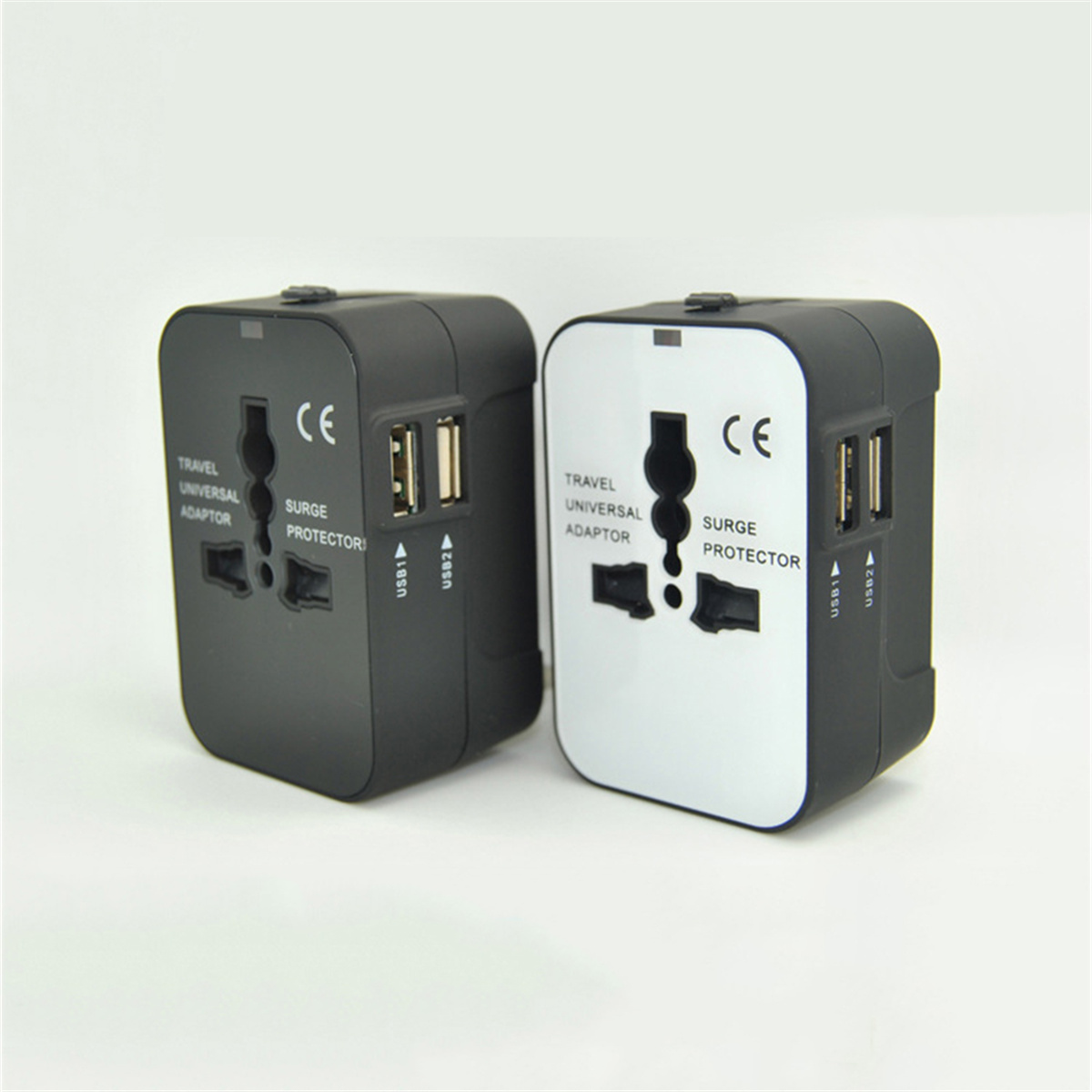 Zwei Universal-Reiseadapter. Einer schwarz, der andere weiß, beide mit Universal-Buchsen.