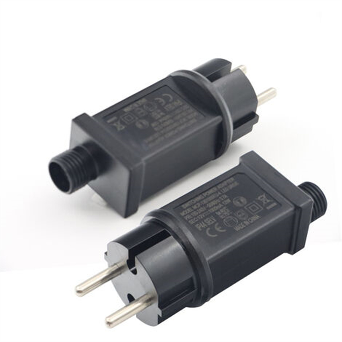 Zwei schwarze Netzadapter mit Stiften, isoliert auf weißem Hintergrund.