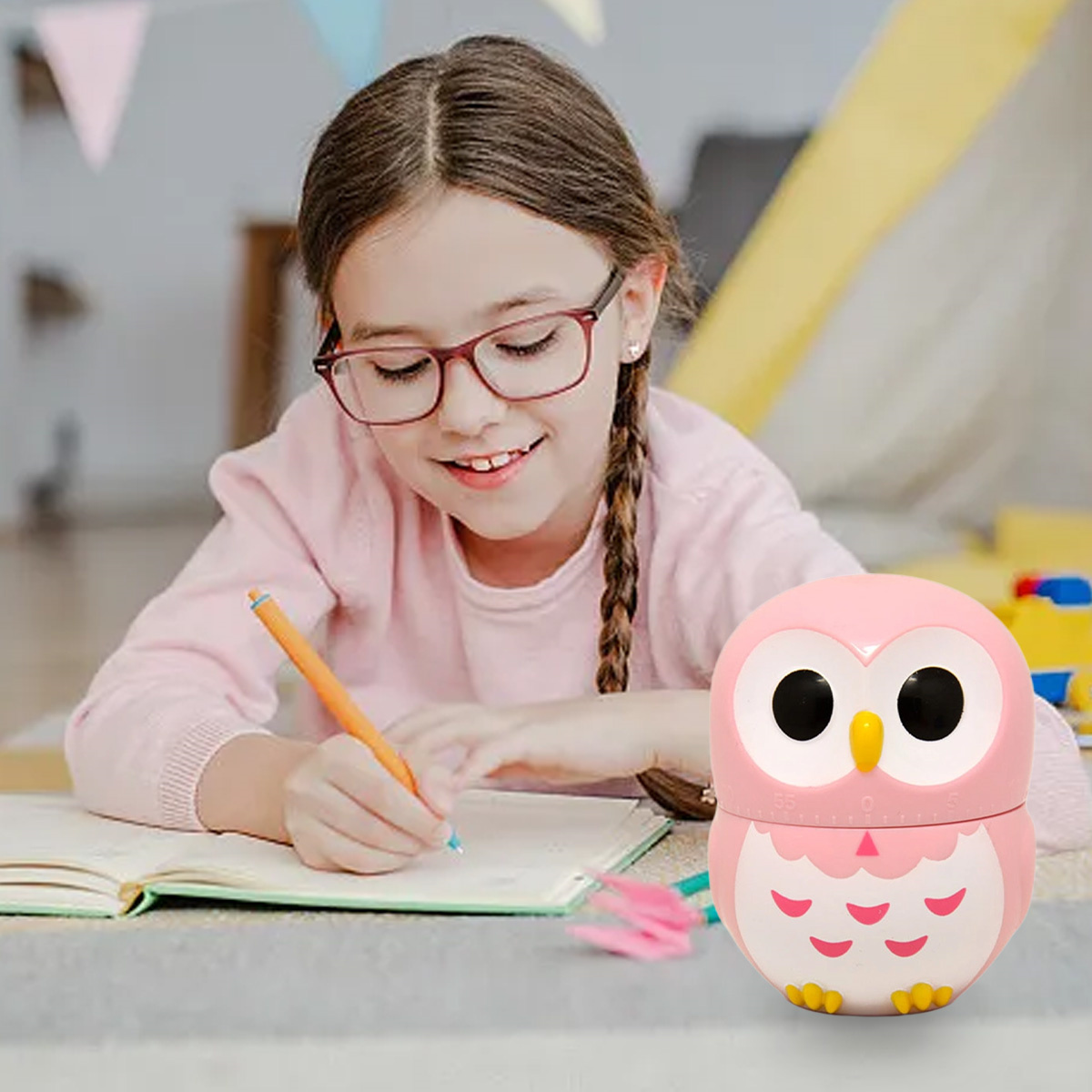 Ein Mädchen mit Brille schreibt mit einem Stift neben einem eulenformigen Timer.