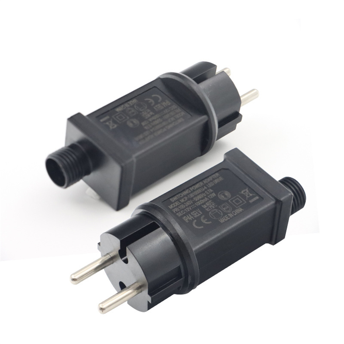 Zwei schwarze Netzadapterstecker mit Stiften. Weißer Hintergrund.