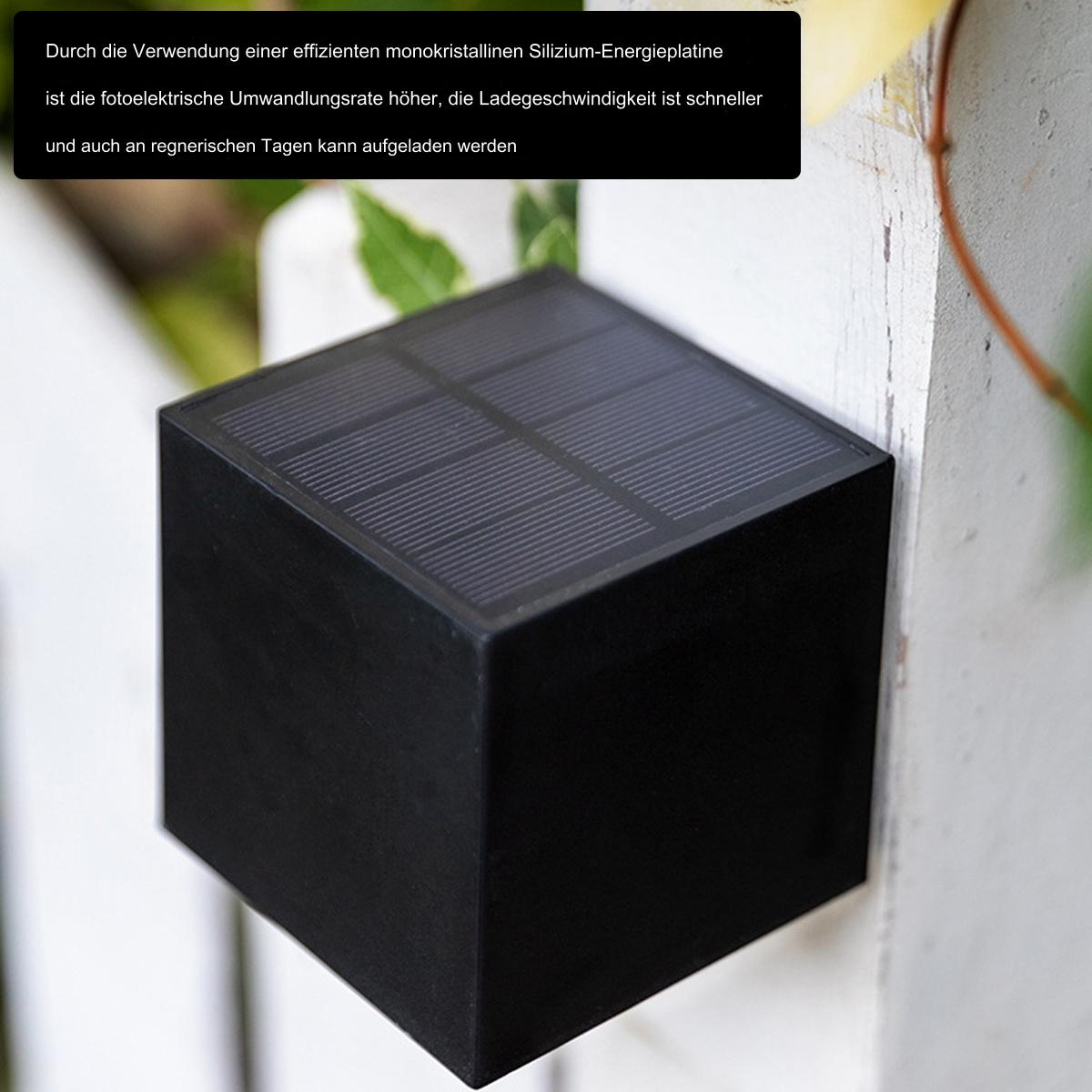 Ein schwarzer, solarbetriebener Würfel, der an einem weißen Holzpfosten befestigt ist.
