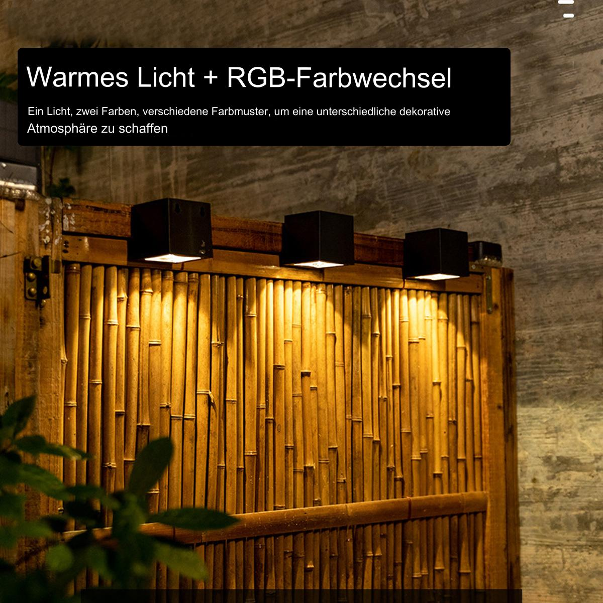Außenleuchten an einer Bambuswand, die warmes Licht und RGB-Farbwechsel aussenden. Die Lampen sind quadratisch.