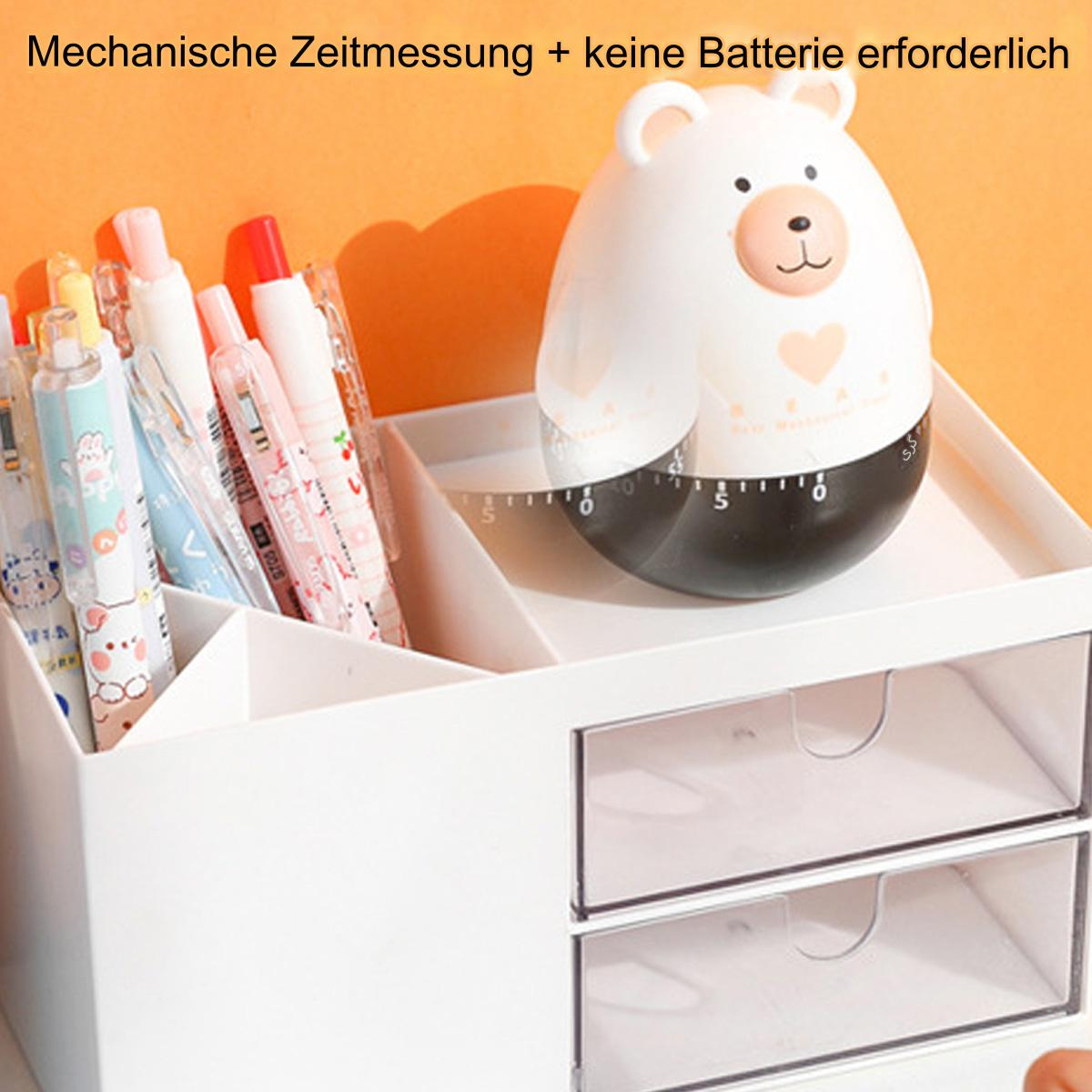 Weißer Schreibtisch-Organizer mit Schubladen und Stiften. Ein bärenförmiger Timer steht oben drauf.
