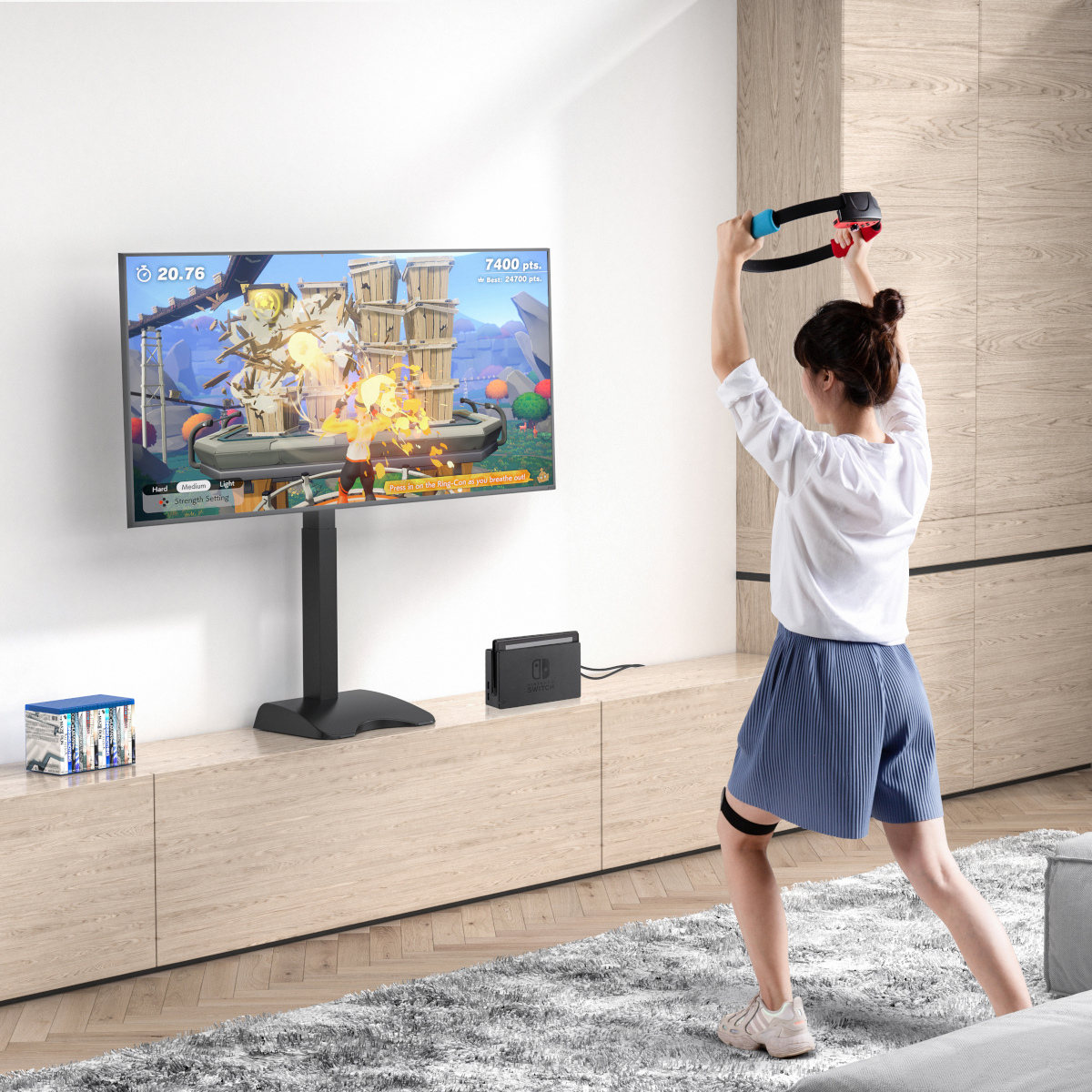 Frau trainiert mit Ring-Fit-Controller vor einem Fernseher.