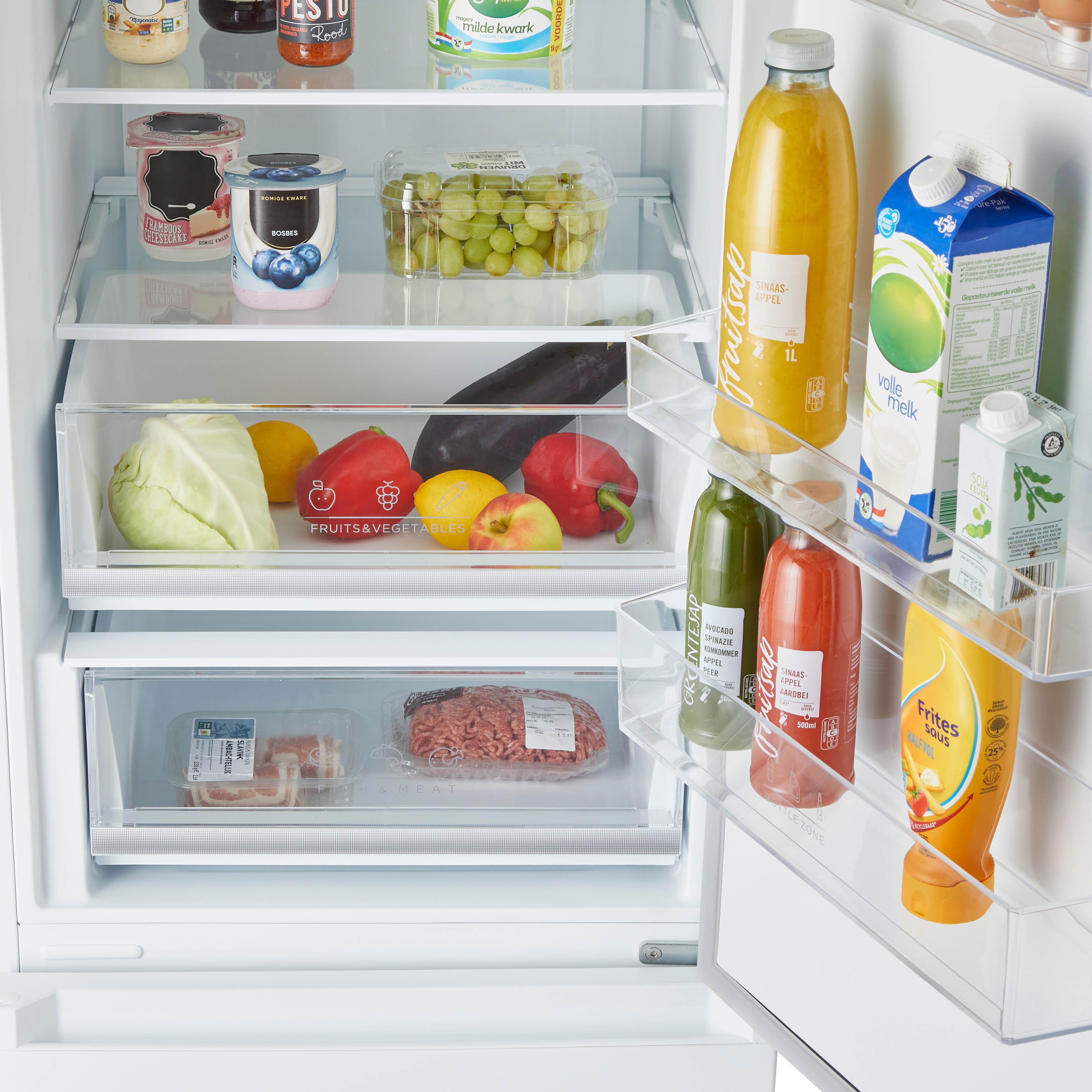 Open koelkastinterieur gevuld met voedsel. Fruit, groenten en verpakte artikelen zijn zichtbaar.