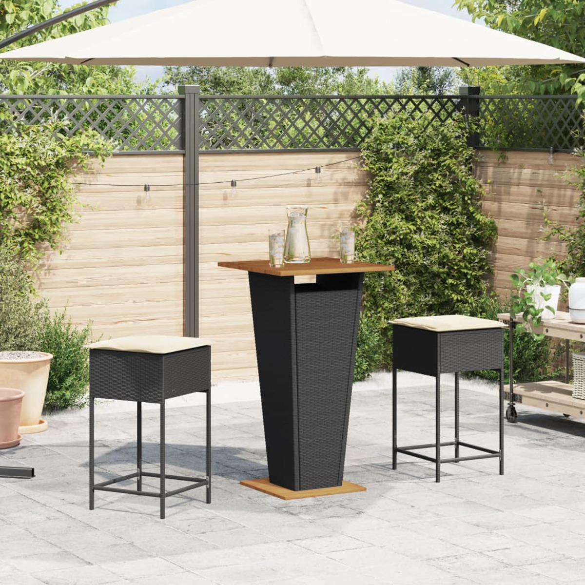 Ein Outdoor-Terrassenset mit einem hohen Tisch und zwei Hockern. Es gibt einen Sonnenschirm, Pflanzen und einen Holzzaun.