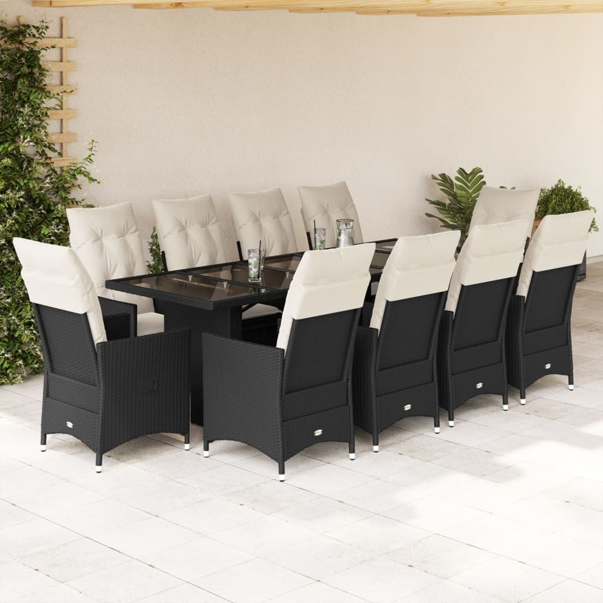 Ein Terrassen-Ess-Set mit zehn Stühlen und einem rechteckigen Tisch. Die Stühle sind schwarz mit cremefarbenen Kissen.