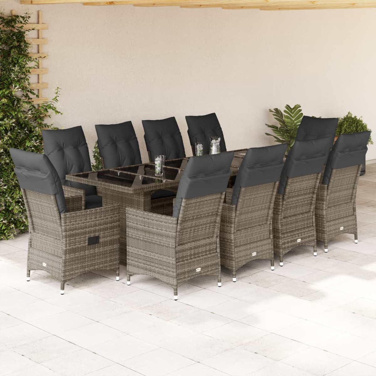 Essgruppe im Freien auf der Terrasse. Graue Korbstühle umgeben einen Tisch mit Glasplatte.