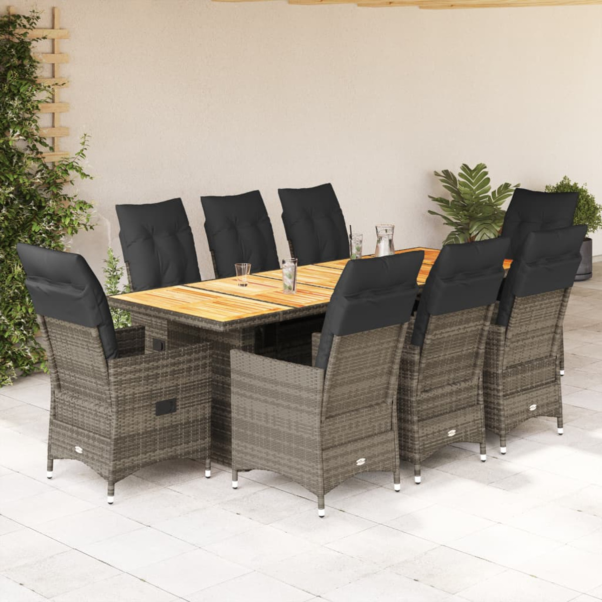 Essgruppe im Freien. Rattan-Stühle mit schwarzen Kissen um einen Holztisch. Beiger Hintergrund.