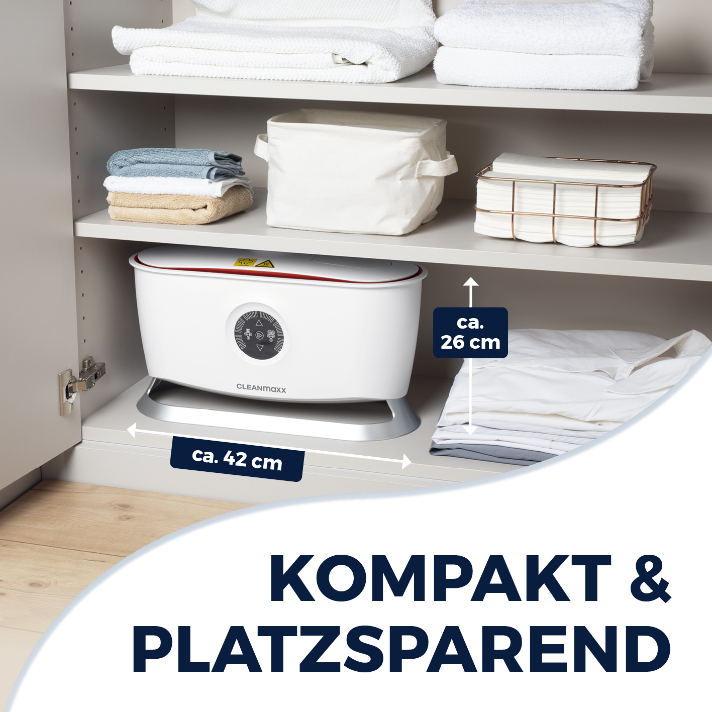 Ein weißes und rotes Gerät in einem grauen Schrank mit Handtüchern, einer Box und einem Korb auf Regalen.