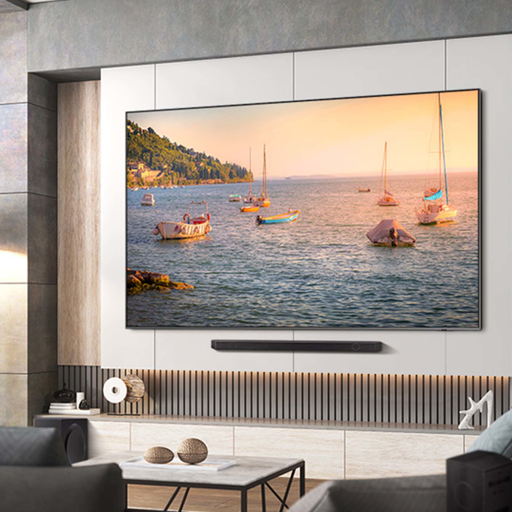 Schermo grande, barche sull'acqua sullo sfondo, soundbar sotto e ambientazione soggiorno.
