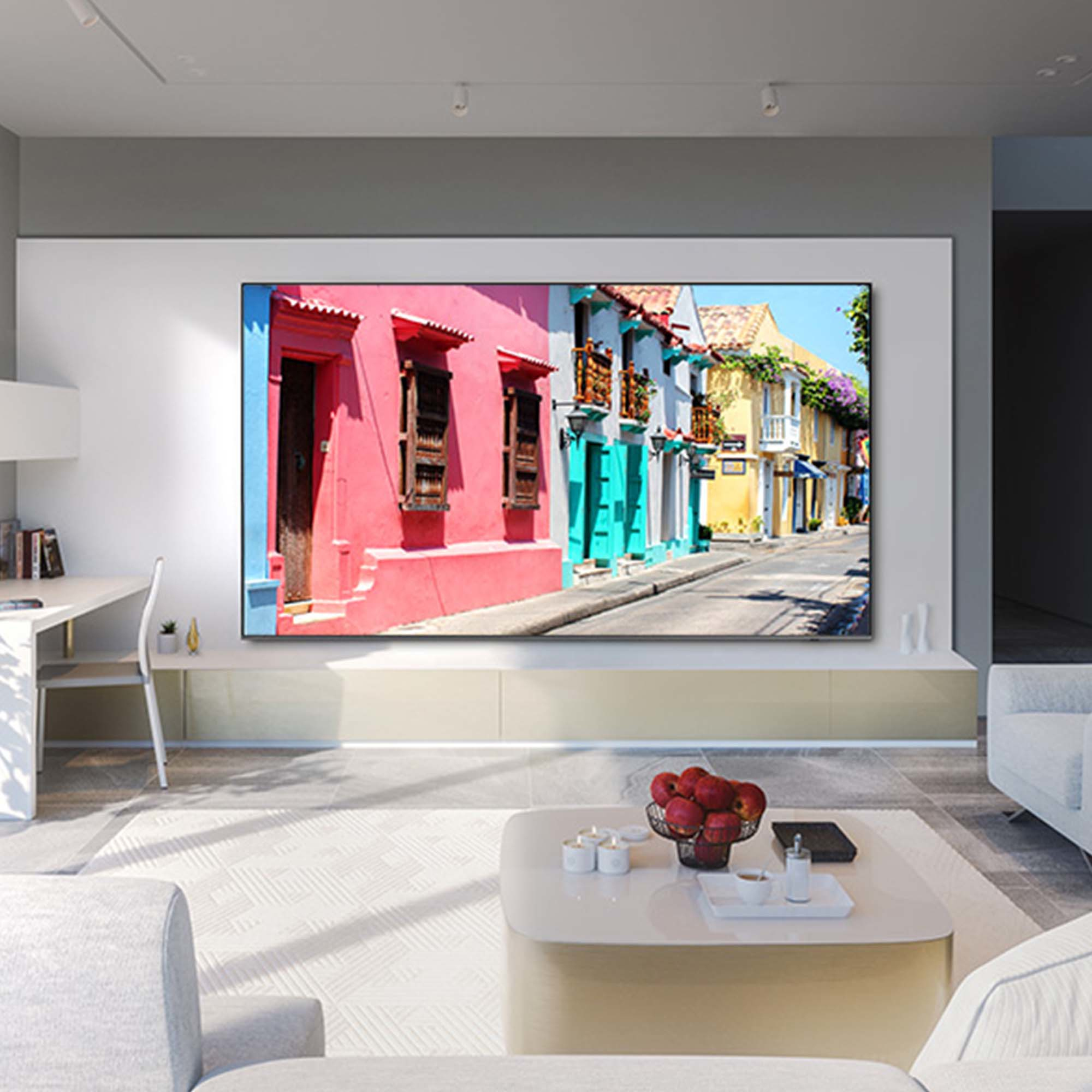 Grande TV mostra una scena di strada colorata. Interno con pareti bianche, mobili e tappeto.