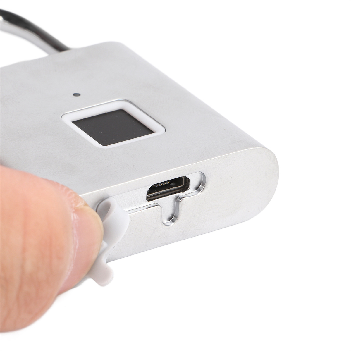 Silbernes Vorhängeschloss mit Fingerabdrucksensor, USB-Anschluss und einem Finger, der es berührt.