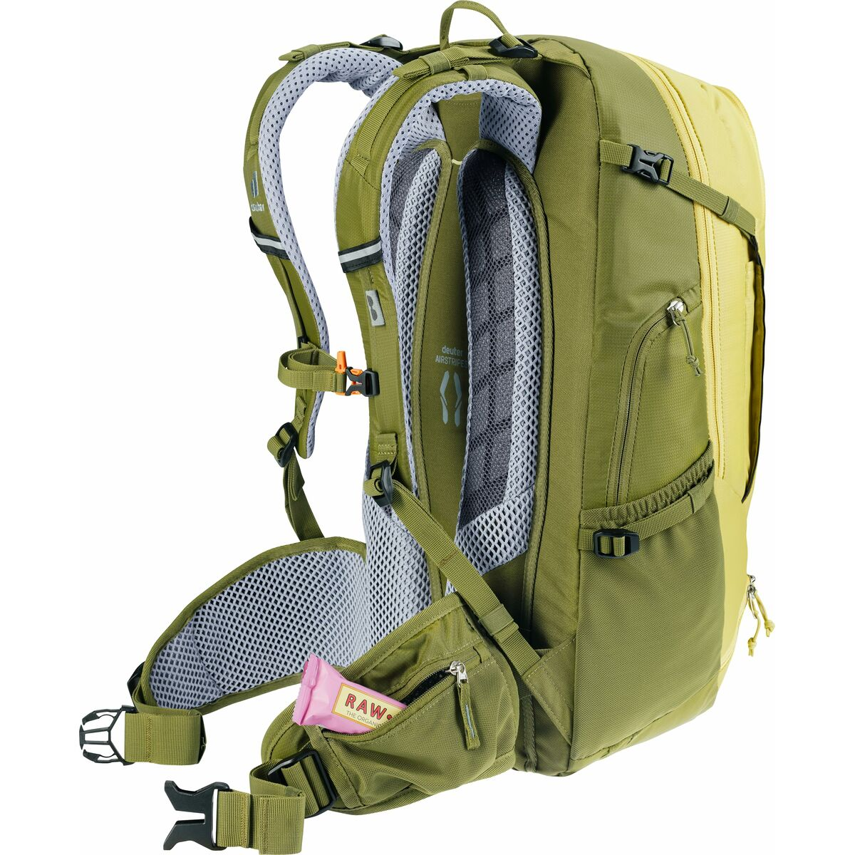 Grüner und gelber Rucksack mit Trägern. In einer Tasche ist ein rosa Riegel.
