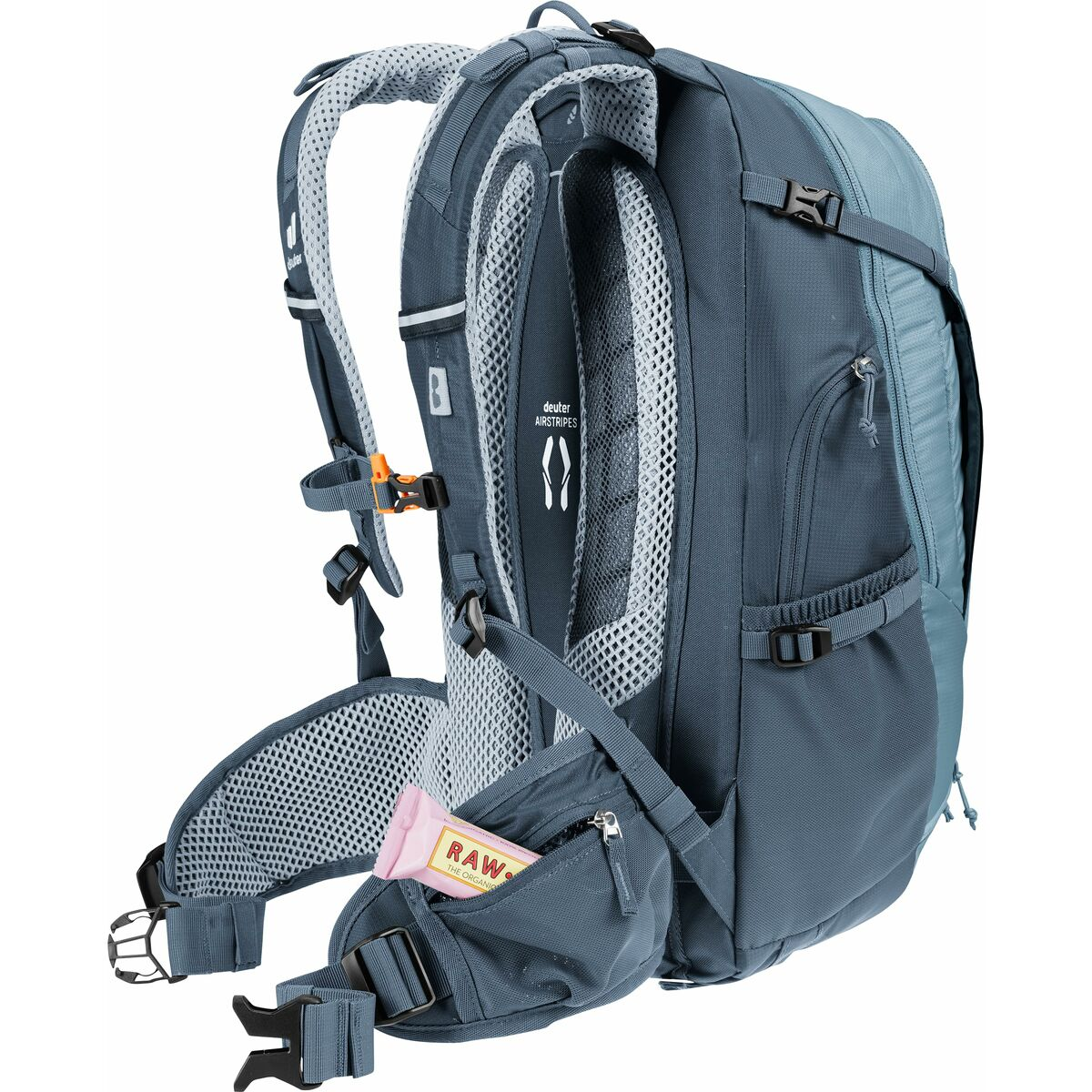 Blauer Rucksack mit einem Snack in der Seitentasche. Der Rucksack steht auf weißem Hintergrund.